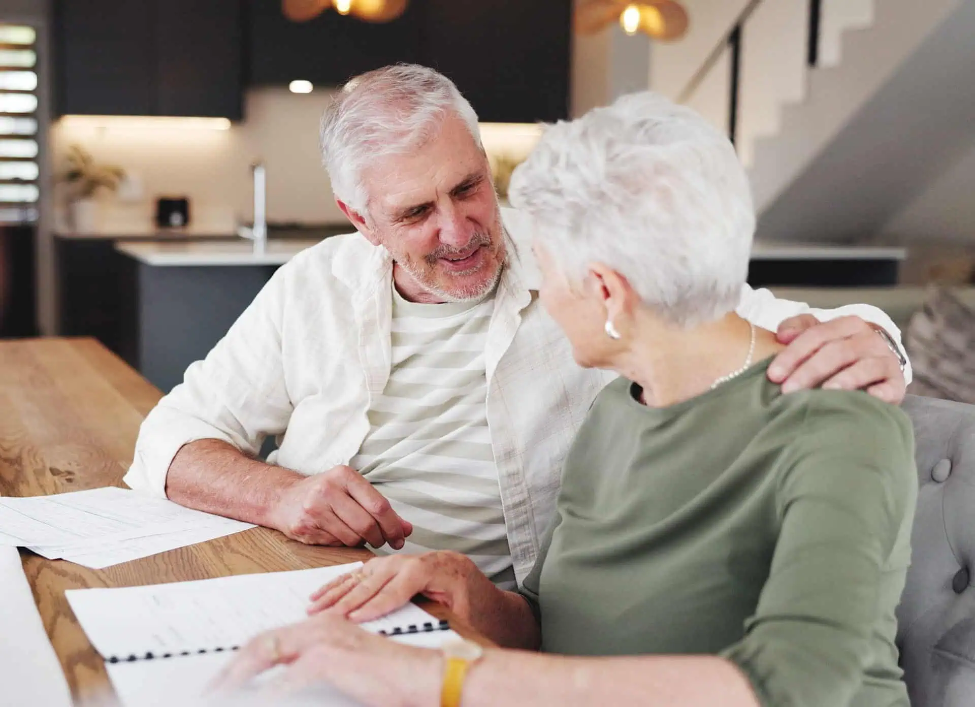 Elderly man and woman sharing a warm moment indoors.