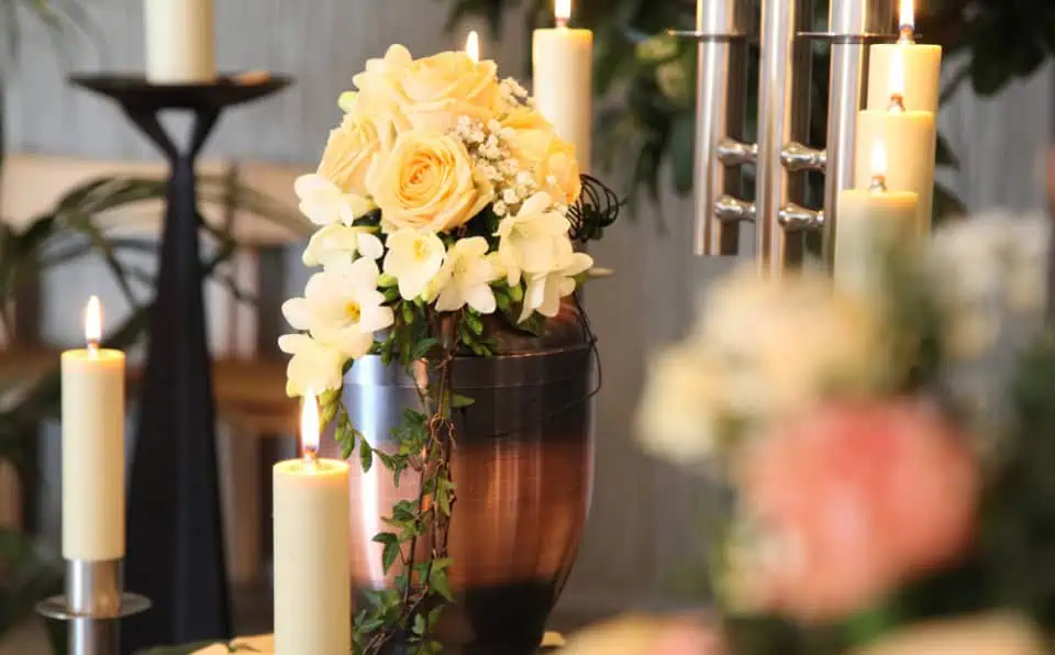 Elegant floral arrangement with candles at a memorial service.