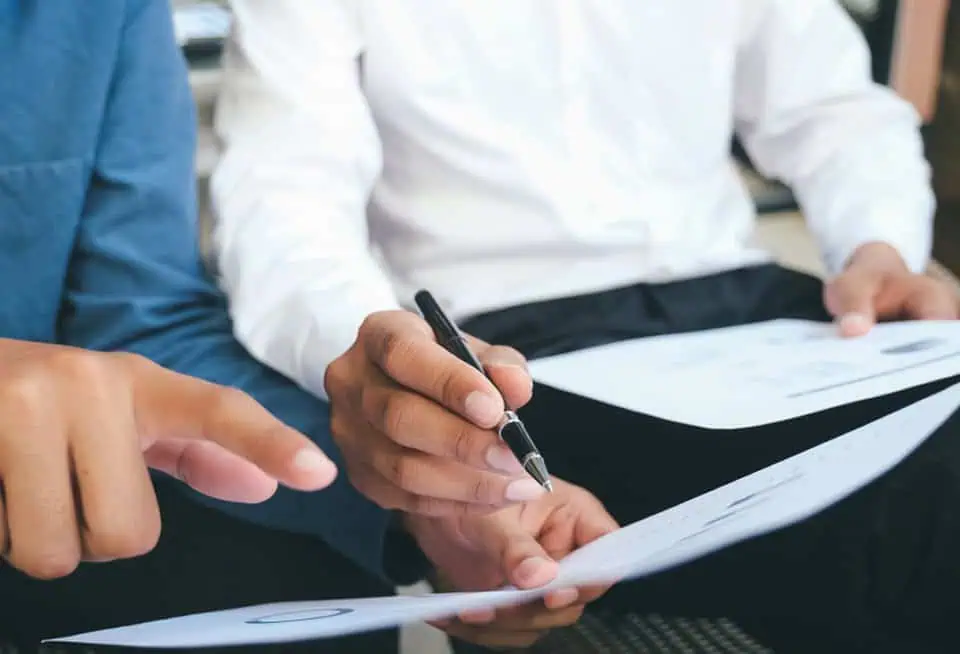 Two people reviewing documents at a memorial service planning meeting.