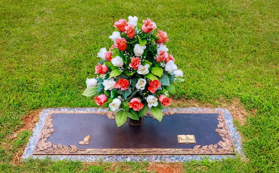 Colorful flower arrangement on a grave marker at a memorial park.