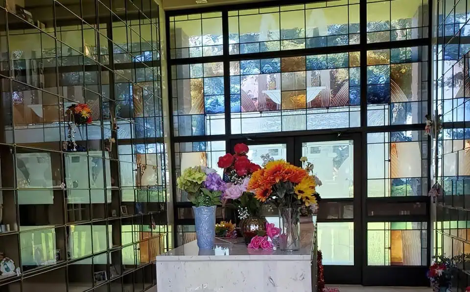 Vase with colorful flowers inside a glass display case.