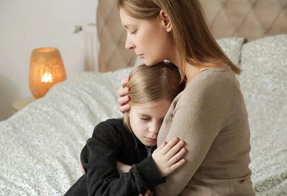 Mother and daughter sharing a tender moment in a cozy bedroom.