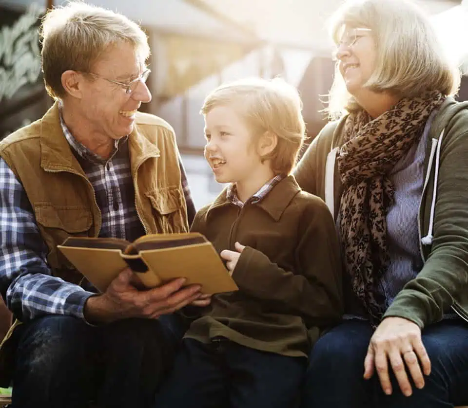 Family enjoying a moment together at a memorial park, with a young boy and elderly couple smiling.