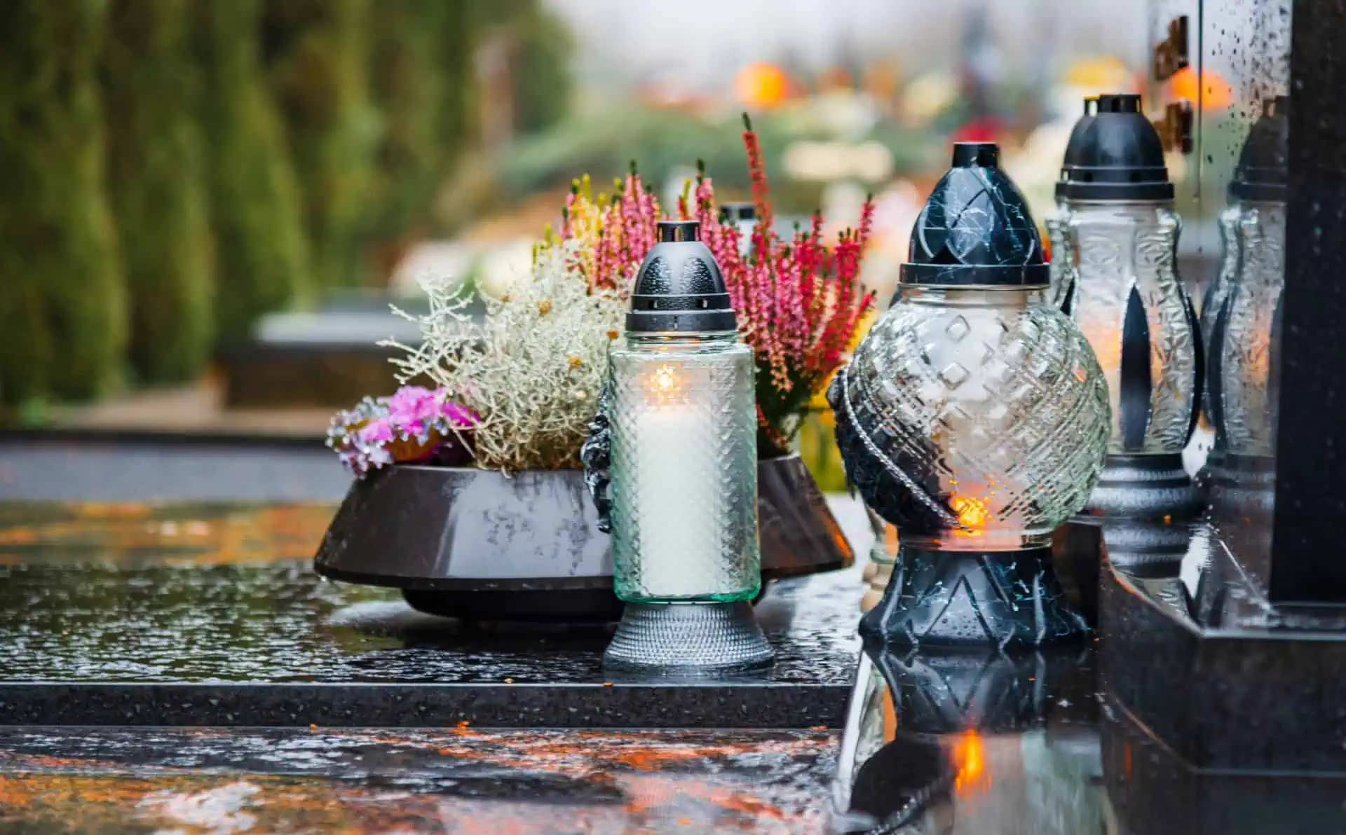 Memorial lanterns and flowers on a wet grave at Mountain View Memorial Park.