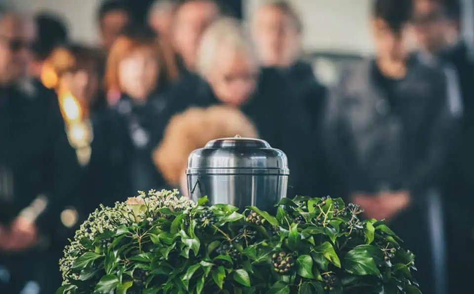 People gathered around a casket during a memorial service.