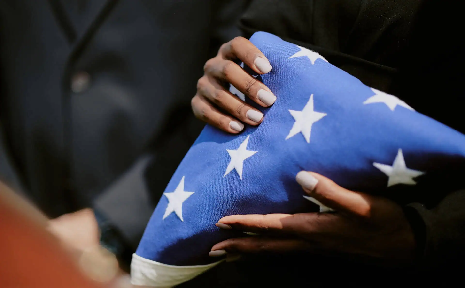 Person folding an American flag during a memorial service.