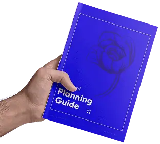 Hand holding a blue planning guide booklet with a flower illustration.