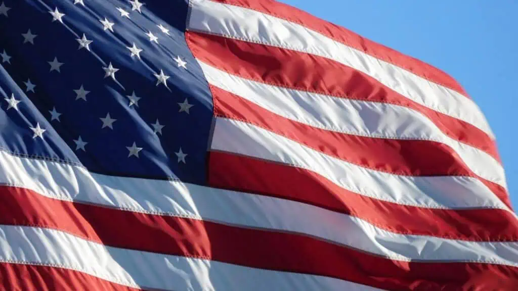 American flag waving in the wind against a blue sky.